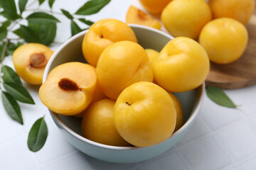 Ripe yellow cherry plums on white tiled table, closeup