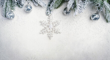 Christmas and New Year background with fir branches with holiday decorations and pine cones on a white table, banner for holiday screen, template for design. Holiday card