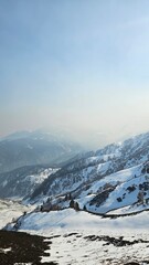 Mountain range covered in snow with a clear blue sky in the background