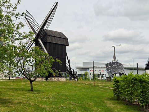 Old Windmill and Modern Photovoltaic Installation in front of the European Spallation Source Building near Lund, Sweden