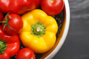 Fresh vegetables in bowl. Yellow bell pepper with red tomatoes and paprika closeup. Natural organic food concept. Healthy raw vegetables on kitchen table. Colorful summer harvest for cooking.