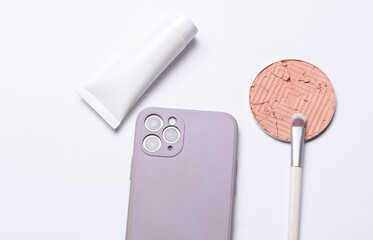 Smartphone and eye shadow on white background. Women's accessories