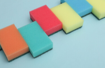 Set of colored cleaning sponges on a blue background