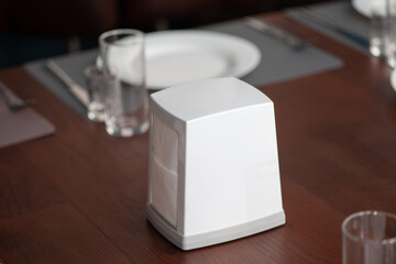 White napkin holder box on restaurant table. Mockup for design