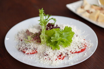 Restaurant dish tomato slices with grated cheese