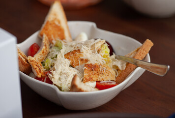 Caesar salad in a plate on the table