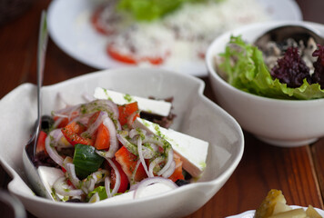 Greek salad on the table with other dishes. Restaurant food