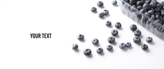 Blueberries in a plastic box on a white background. Top view. Copy space