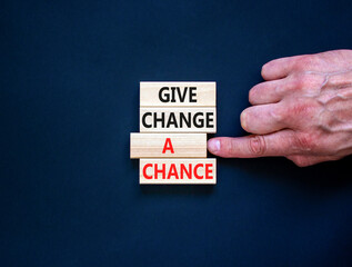 Give change a chance symbol. Concept words phrase Give change a chance on beautiful wooden blocks. Beautiful black paper background. Businessman's hand Business Give change a chance concept Copy space