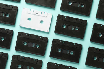 White and black audio cassettes on a blue background. Uniqueness, exclusivity concept