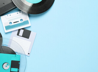 Floppy disk, vinyl record, vhs and audio cassette on blue background. Retro 80s. Top view