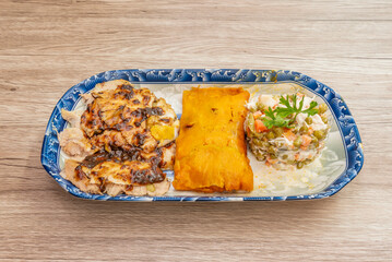 Traditional tamales fresh from the pot, featuring a soft corn masa colored with achiote and generously filled with pulled pork and red sauce