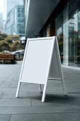 Blank white outdoor sign in front of modern buildings