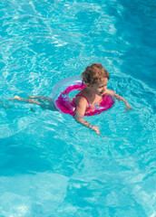Child swimming in a pool with a ring. Selective focus.