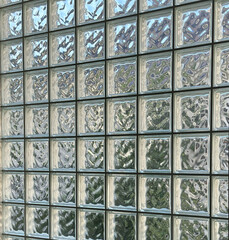 Glass block wall with abstract reflections and natural lighting for interior design and architectural concept