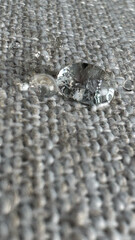 Water droplet on grey textile surface: detailing waterproof fabric properties for fashion and home decor concept of textile manufacturing, interior designers, clothing brands
