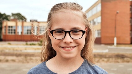 Smiling blonde 11 year old girl with glasses.
