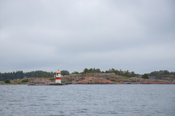 Marine channel marker on coastal rocks, indicating the edge of the channel. Coastal navigation aid in Baltic sea, highlighting safety, marine guidance, and rocky shoreline