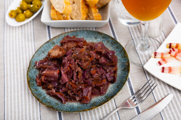 Appetizing spicy baked pork ribs with vegetable garnish of braised red cabbage on plate