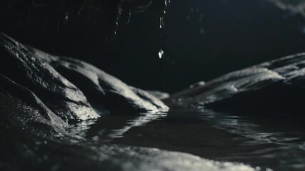 Ethereal Slow Motion Water Drop Splashes into a Dark Reflective Pool Inside a Mysterious Cave. - Powered by Adobe