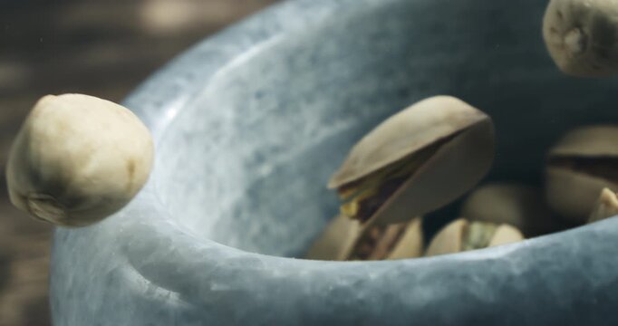 Super Slow Motion Macro Of Unshelled Pistachios Falling Into Stone Mortar, Organic Nuts With Shell On Wooden Table, Healthy Snack And Ingredient For Cooking Baking Dessert And Cuisine At 1000 Fps