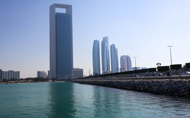 Obraz premium Modern Abu Dhabi skyline with high-rise towers, wide streets, and city lights showcasing the UAE’s capital’s urban beauty.