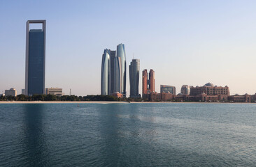 Fototapeta premium Modern Abu Dhabi skyline with high-rise towers, wide streets, and city lights showcasing the UAE’s capital’s urban beauty.