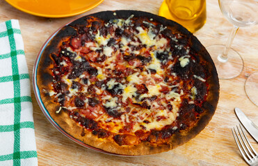 Hot pizza with jamon, cheese and tomatoes.