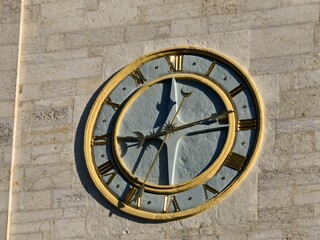 Time ticks on a classic clock face on a stone wall showing the passage of time