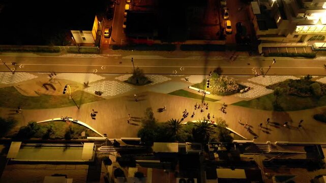 City at Dusk: Aerial view of a city street at night, with warm streetlights casting an inviting glow on the pedestrian walkways.
