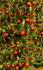 Christmas tree green holiday background. New Year fir tree close up with decor, branches, toys, baals and garlands