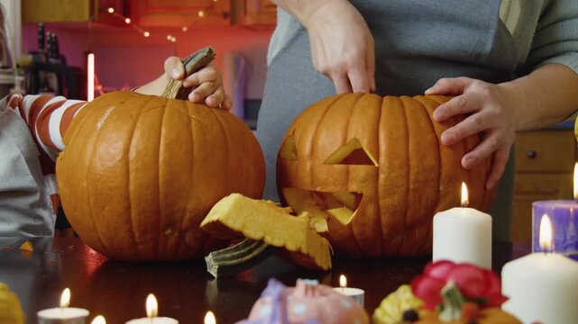 Halloween Pumpkin Carving With Mom A Loving Mother Helps Her Little Son And Daughter Prepare A Pumpkin Lantern For Halloween, Capturing A Happy Family Moment Filled With Love, Joy, And Excitement.