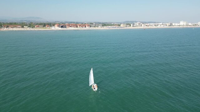 Seafarer on Turquoise Waters: A lone sailboat cuts through the tranquil expanse of shimmering turquoise waters, offering a visual ode to solitude and freedom.