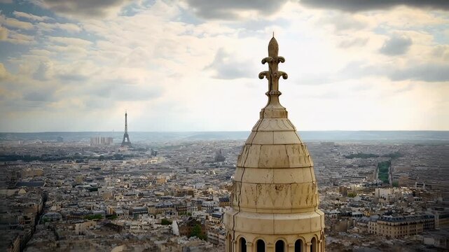 Paris, France. Aerial view of Paris cityscape with Eiffel Tower and ornate spire against a partly cloudy sky.