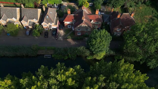 Aerial view of Government Row, Enfield Island Village, with rooftops, streets, and the River Lea Navigation running alongside the residential area