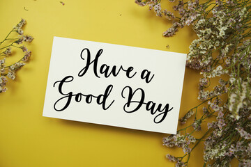 Have a Good Day text with flowers decoration on yellow background
