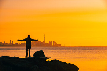Toronto skyline in the morning. Silhouette figure of a man enjoying the Toronto sunrise