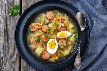Polish sauerkraut soup with sausage in a bowl