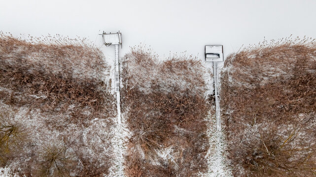 Aerial view of snow-covered jetty over lake in winter.