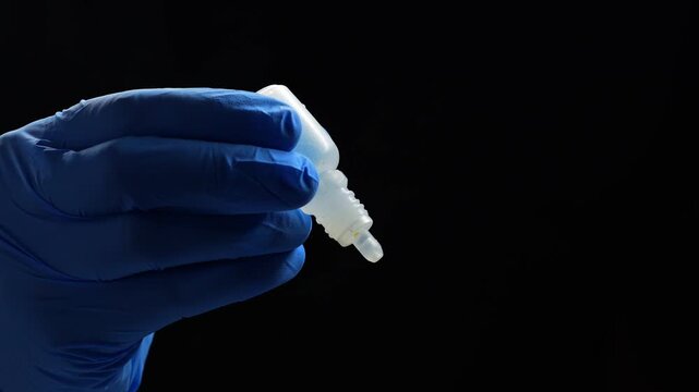 Doctor in blue gloves holds a bottle of eye drops.
Treatment of poor grain and dry eyes.
Dry eyes from sitting at a laptop for a long time.
Ophthalmology concept