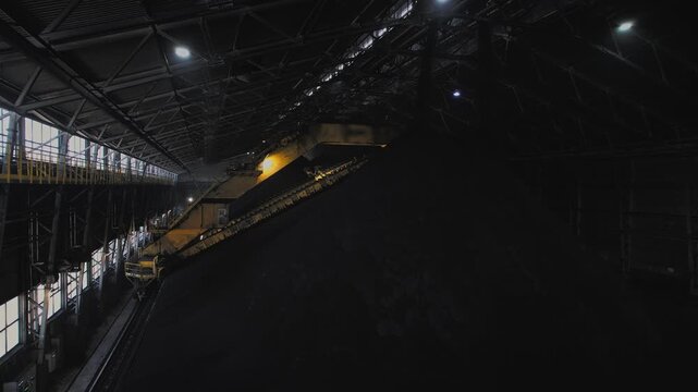 Automatic conveyor loads magnetite large warehouse iron ore at factory on open pit mine.