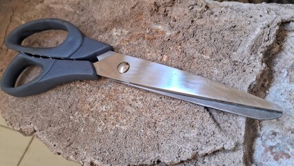 Obraz premium Scissors on a rough textured surface