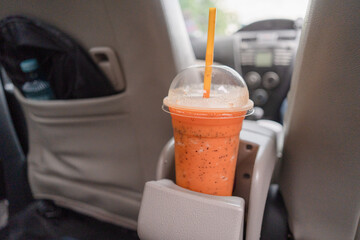 A smoothie fruits recipe glass center in a car and exposed to sunrise