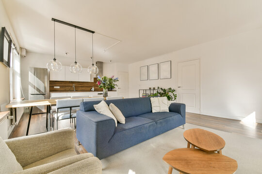 Modern open-plan living room with blue sofa and kitchen
