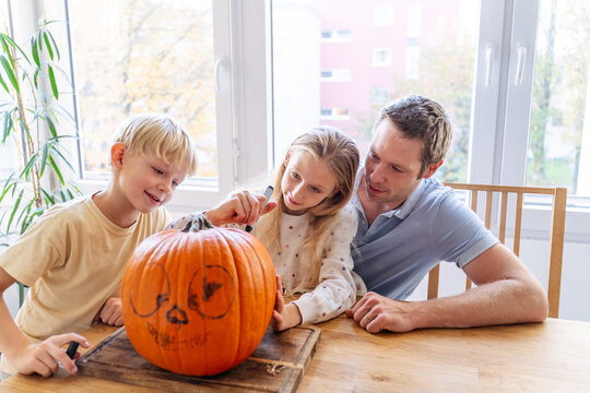 Family carving pumpkin together for Halloween fun