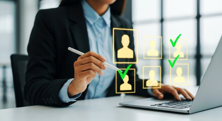 A person reviews profiles on a laptop, marking selections with checkmarks. A symbol of selection, screening, and decision-making. Recruitment process, talent acquisition, workforce planning.