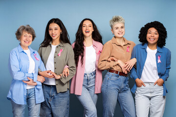 Happy diverse women wearing pink ribbons are fighting breast cancer together