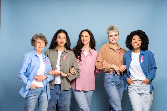 Diverse women showing pink ribbons for breast cancer awareness - Powered by Adobe