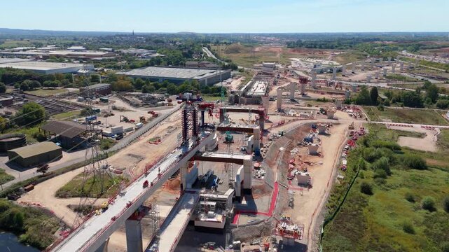 Aerial drone footage of HS2 high speed railway train line infrastructure under construction, bridge beams and heavy plant near Birmingham England UK