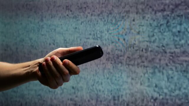 A young guy in front of a TV screen can't tune the channel and sees interference and white noise in front of him.
TV interference in an angry man who wants to watch TV in the evening